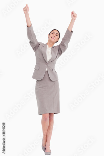 Young businesswoman with arms raised