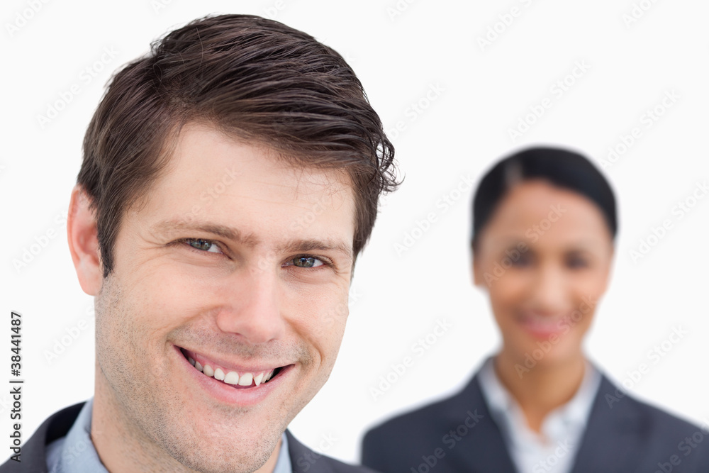Close up of smiling salesman with colleague behind him Close up of smiling salesman with colleague behind him