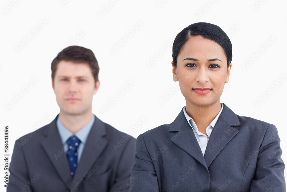 Close up of confident saleswoman with colleague behind her Close up of confident saleswoman with colleague behind her