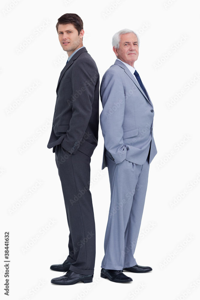 Businessman standing back to back with his mentor Businessman standing back to back with his mentor