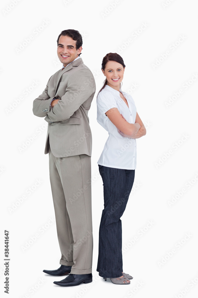 Smiling salesteam with arms folded standing back to back Smiling salesteam with arms folded standing back to back