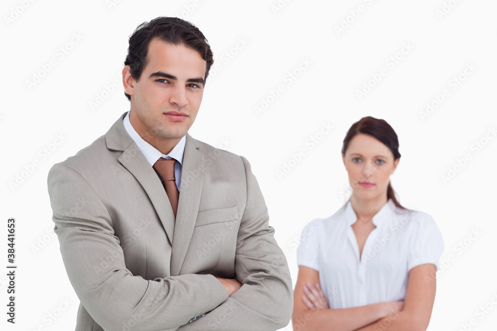 Salesman with arms crossed and colleague behind him Salesman with arms crossed and colleague behind him