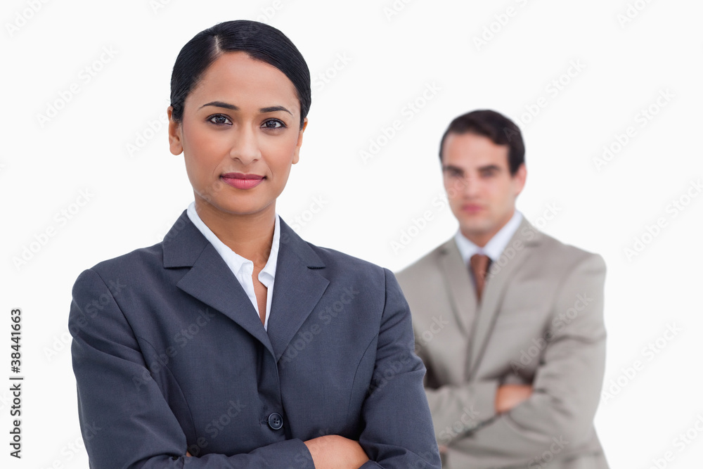 Saleswoman with arms crossed and colleague behind her Saleswoman with arms crossed and colleague behind her