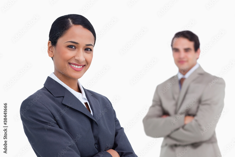 Smiling saleswoman with colleague behind her Smiling saleswoman with colleague behind her