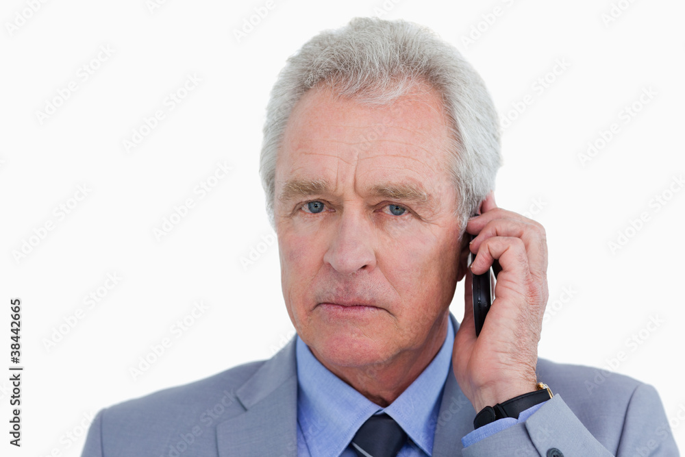 Close up of serious mature tradesman on his cellphone