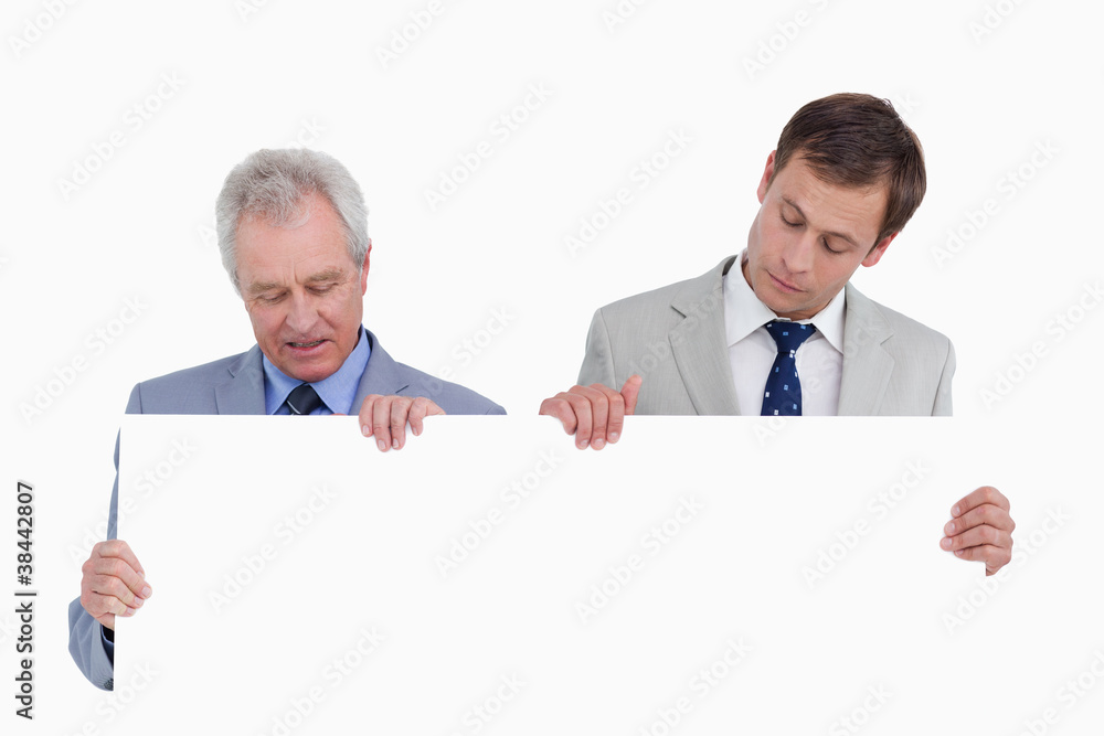Tradesmen looking at blank sign in their hands Tradesmen looking at blank sign in their hands