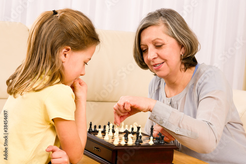 Grandmother and granddaughter play chess together