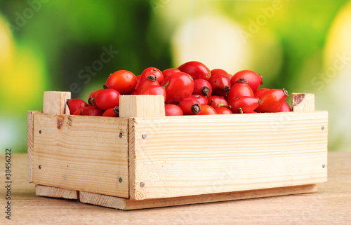 ripe briar in wooden box on wooden table on green background