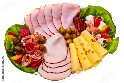 Dish with sliced smoked ham, salami rolls and cheese.