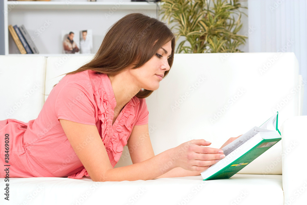 beautiful young woman on the couch with a book beautiful young woman on the couch with a book