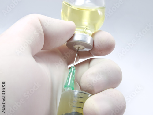 Hand, a syringe and vial