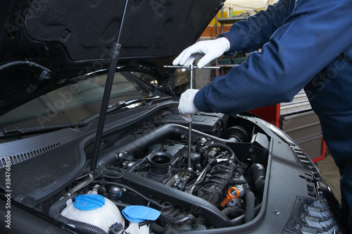 mechanic repairs a car in a garage