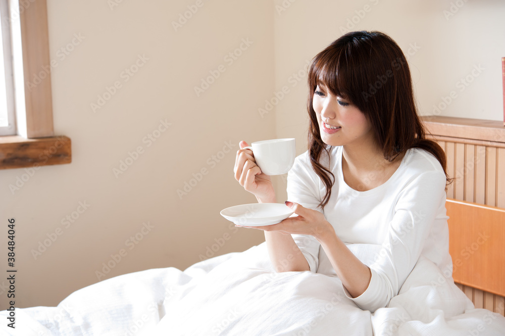 attractive asian woman drinking on the bed attractive asian woman drinking on the bed