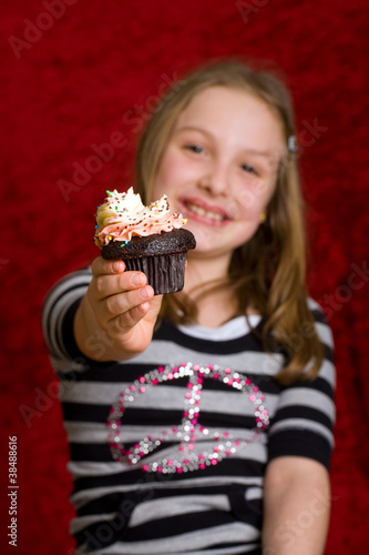 young girl eating a delicious cupcake