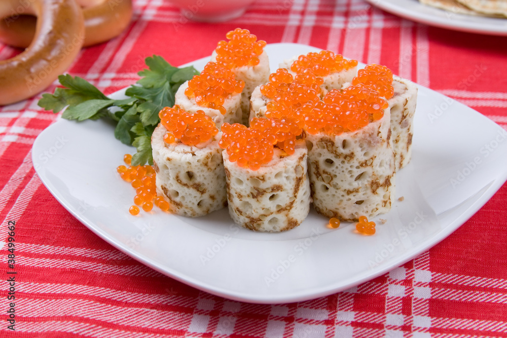 Rolls from pancakes with red caviar on a plate Rolls from pancakes with red caviar on a plate