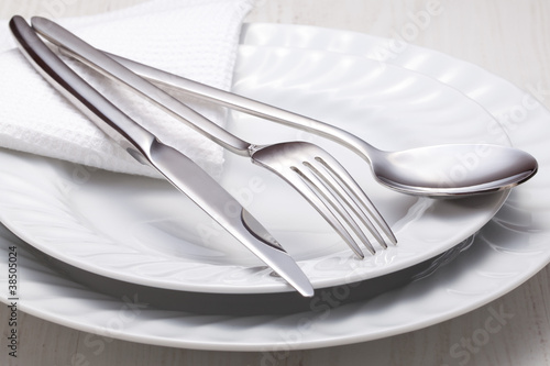 fork, knife, spoon and a white plate