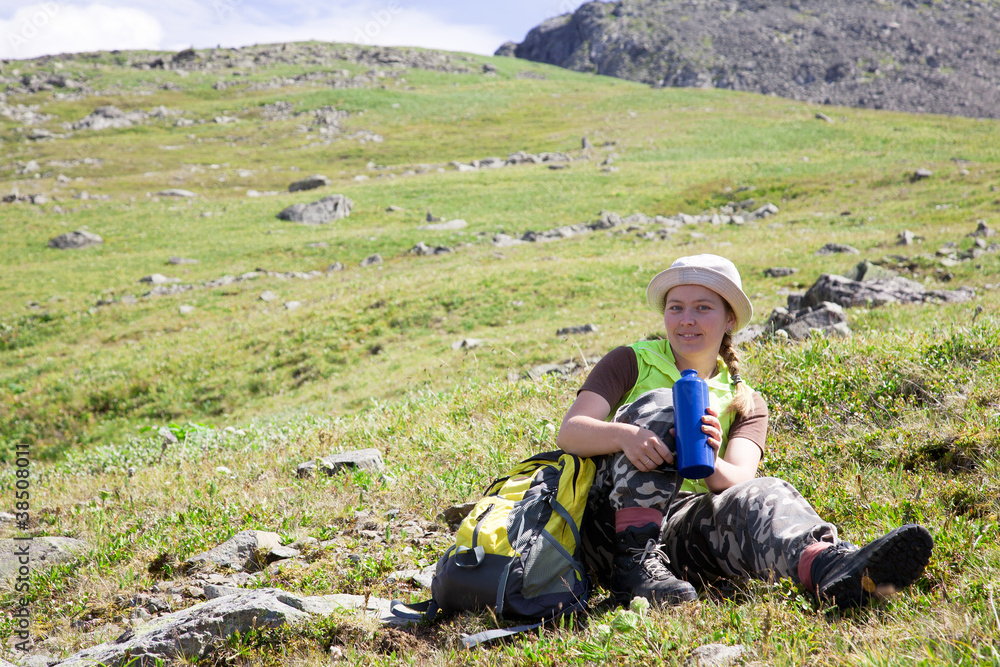 mountains tourist drinking water from bottle at mountain peak