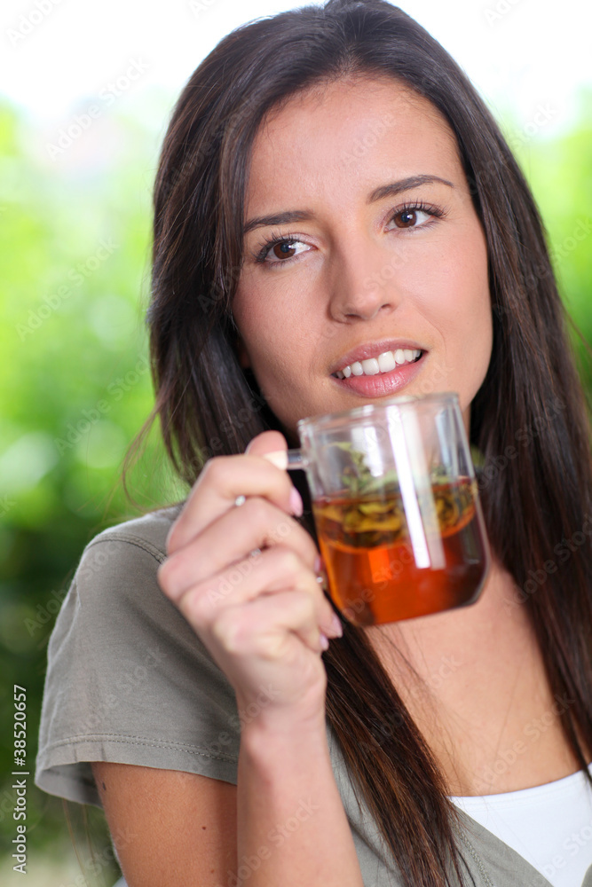 Portrait of young woman drinking herbal infusion