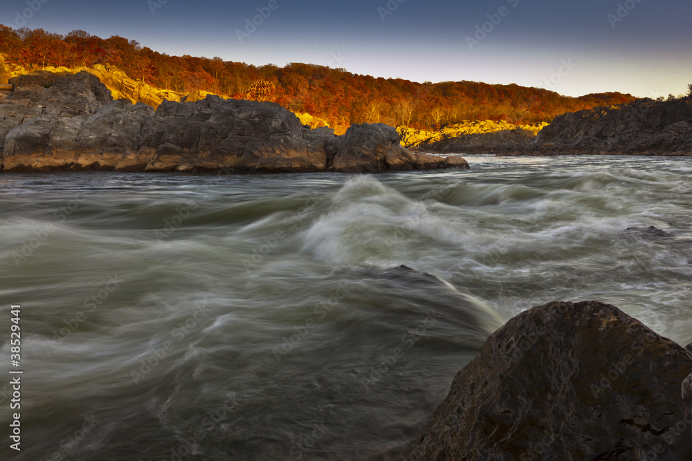 White water river and rocks in sunset light