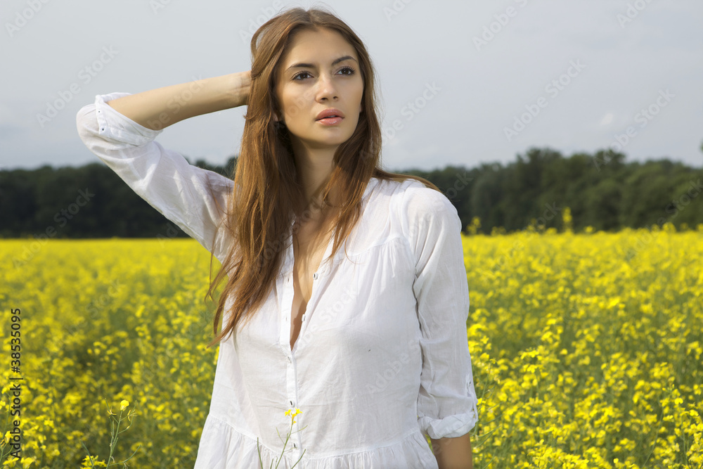 brunette woman in a yellow flowers field brunette woman in a yellow flowers field