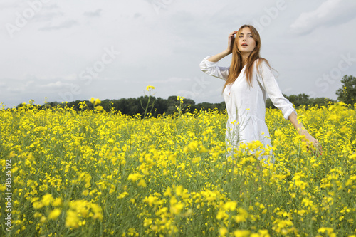 brunette woman in a yellow flowers field © bartekwardziak