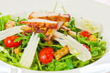 Chicken salad with tomatoes, arugula and bread croutons in the w