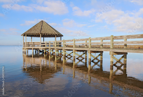 Gazebo, dock, blue sky and clouds over calm sound waters