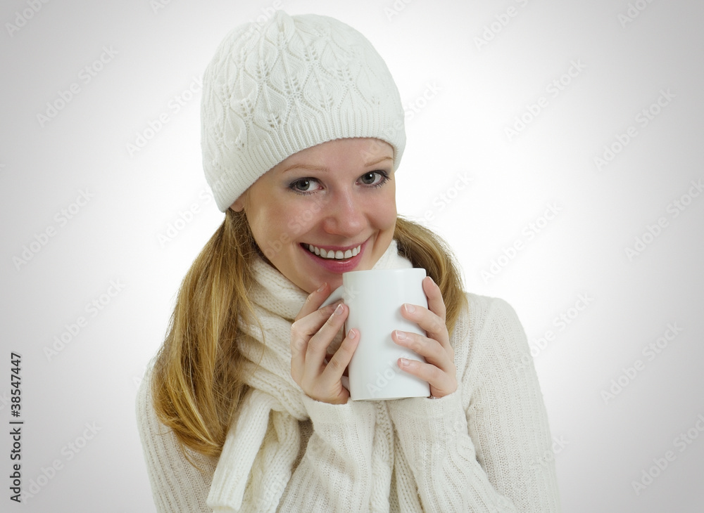 beautiful girl in a winter hat and scarf with a mug of hot drink beautiful girl in a winter hat and scarf with a mug of hot drink