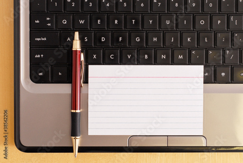 Blank Index Card with Pen on laptop Computer photo