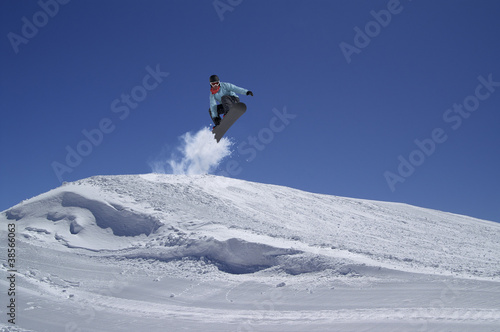 Snowboarder jumping in terrain park