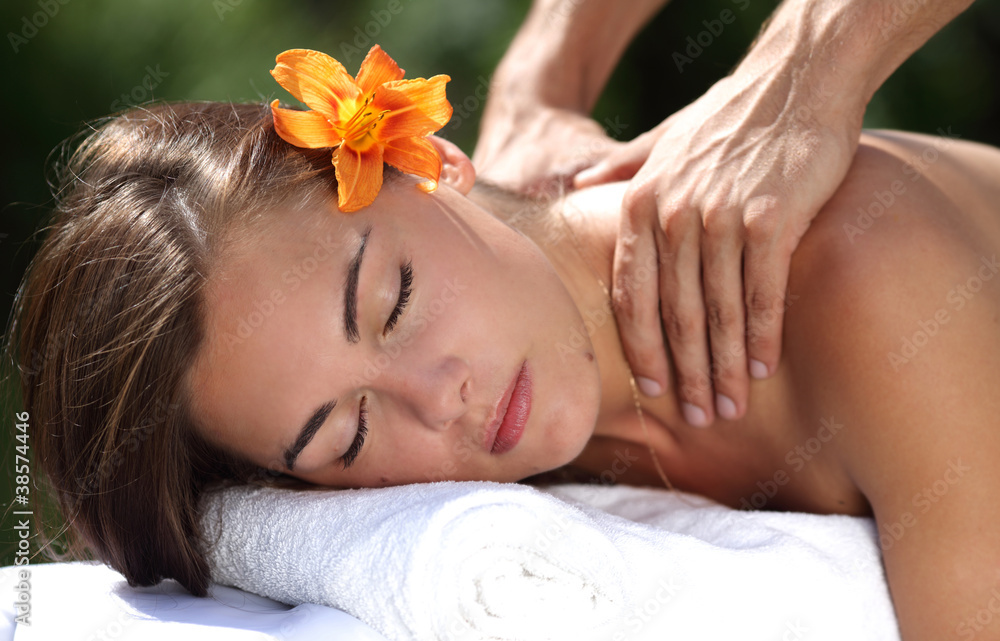 Young woman lying on massage table at spa, outdoors Young woman lying on massage table at spa, outdoors