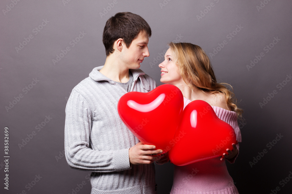 Portrait of two young people holding heart-shaped balloon Portrait of two young people holding heart-shaped balloon