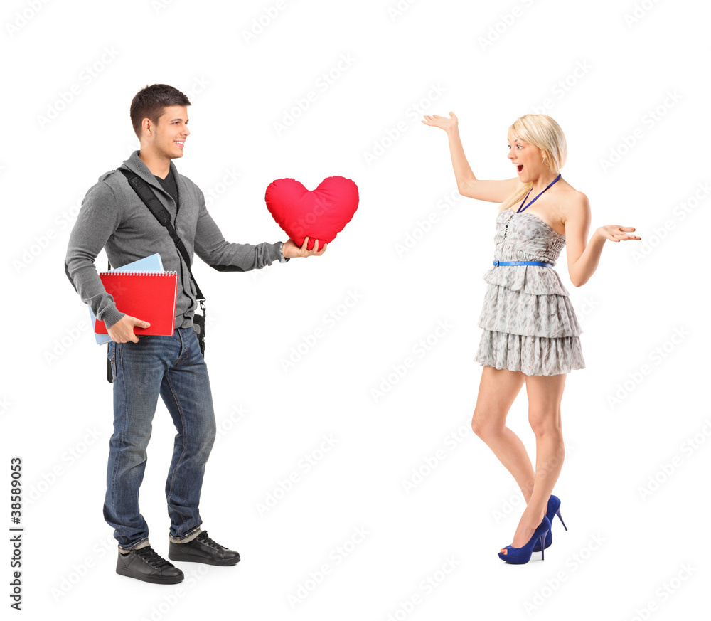 Boyfriend standing with a pillow and a girlfriend extending her Boyfriend standing with a pillow and a girlfriend extending her