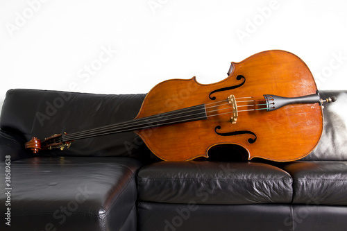 Contrabbasso, strumento ad arco, su divano in pelle nera photo