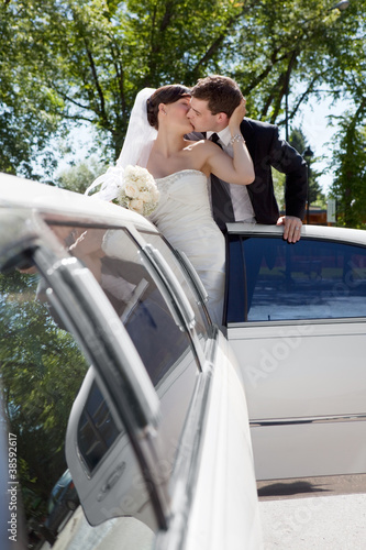 Newlywed Couple Standing Beside Limousine © Tyler Olson
