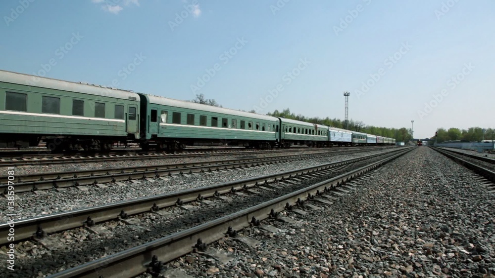 Short train passes by on railway, traffic on bridge far Short train passes by on railway, traffic on bridge far