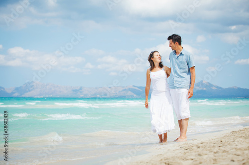 Happy young couple walking on beach © Max Topchii