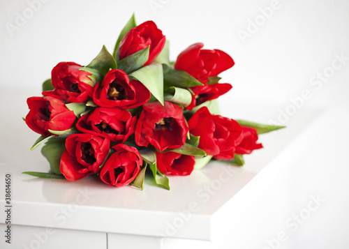 Fototapeta Naklejka Na Ścianę i Meble -  red tulips lying on white table
