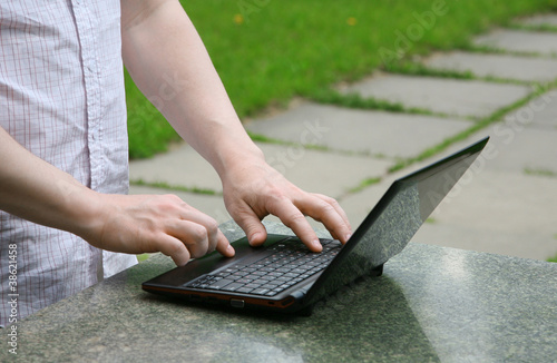 Hands and netbook on street photo