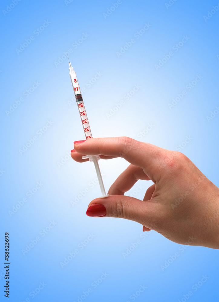 Hand holding syringe isolated on the white Hand holding syringe isolated on the white