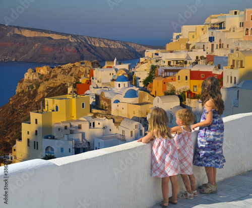 Little girls watching the sunset over Oia village - Greece