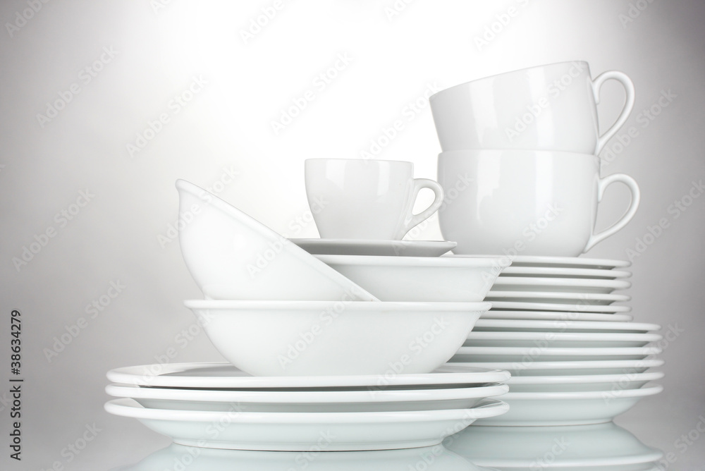empty bowls, plates and cups on gray background empty bowls, plates and cups on gray background