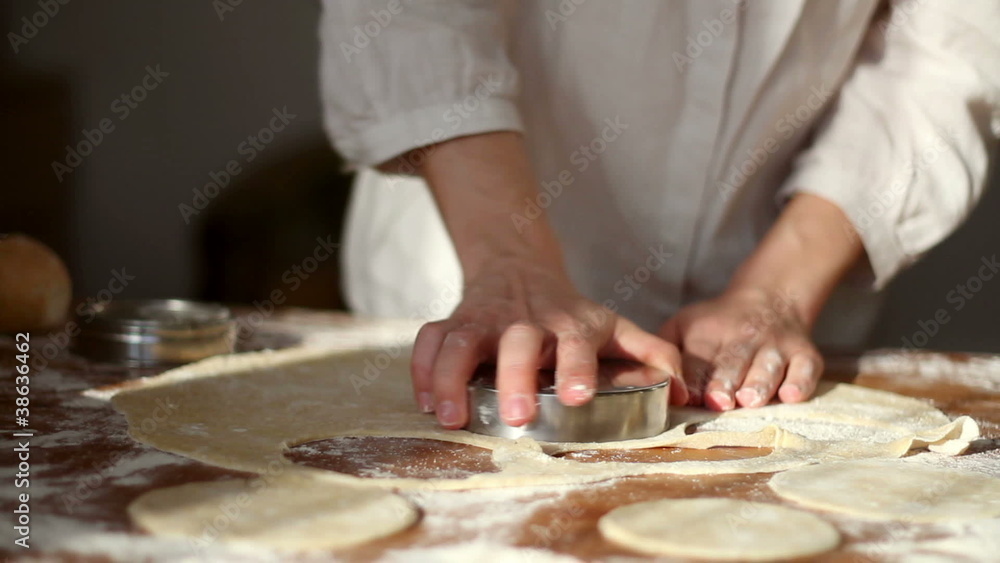 Baker cutting dough with cookie form Baker cutting dough with cookie form
