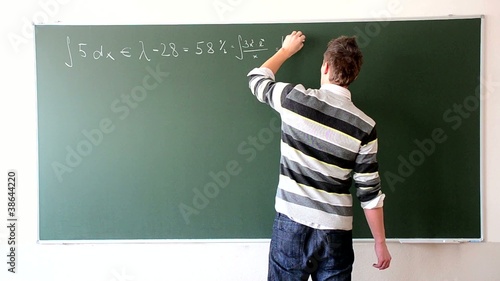 Boy is solving maths problems at the blackboard in fastmotion