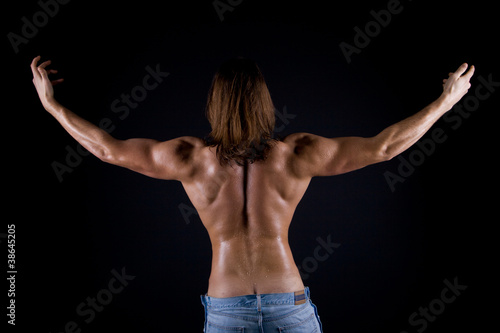 the muscular male back on black background.