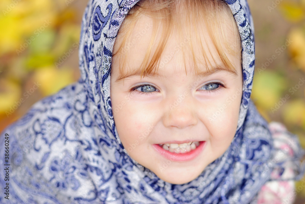 Portrait of the small beautiful girl in a dark blue scarf Portrait of the small beautiful girl in a dark blue scarf