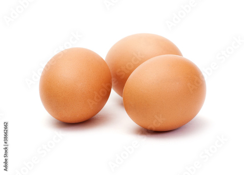 Three brown eggs on white background