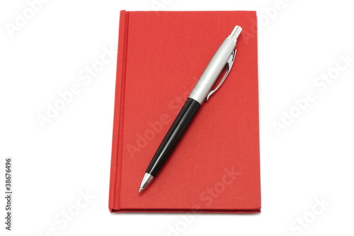 Red notepad with ball pen on a white background