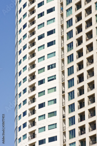 Beige Stucco Condo Tower with Balconies on Blue