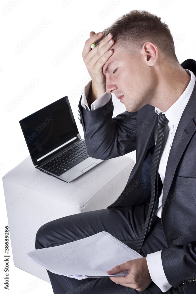 Tired and stressed young businessman working at his computer Tired and stressed young businessman working at his computer